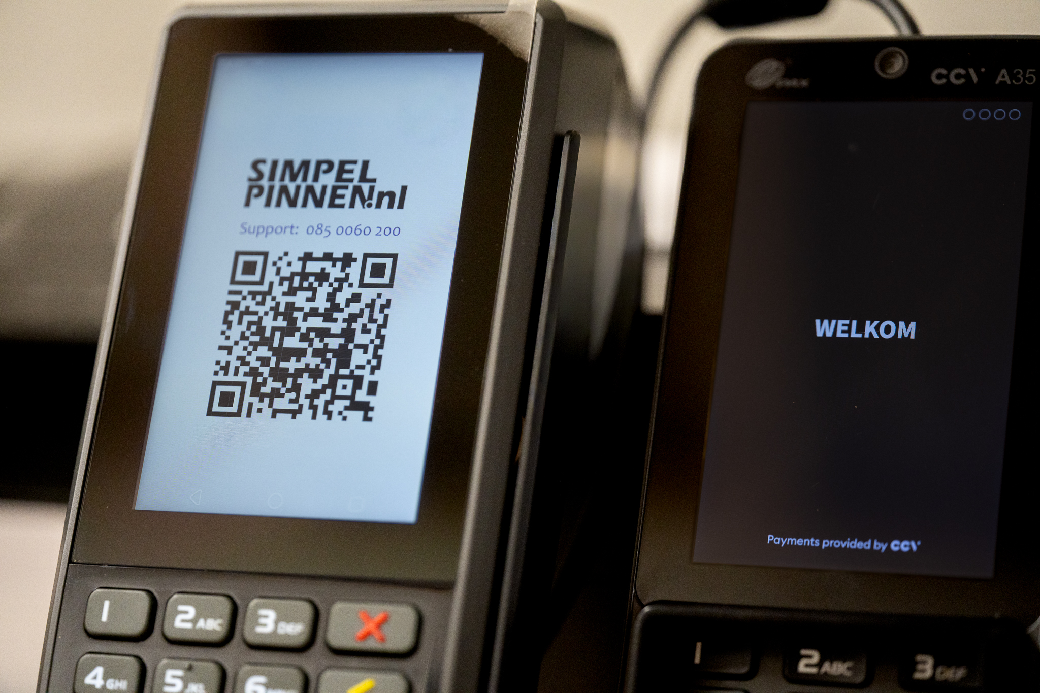 Two card payment terminals installed by ICNT, one showing a payment QR code