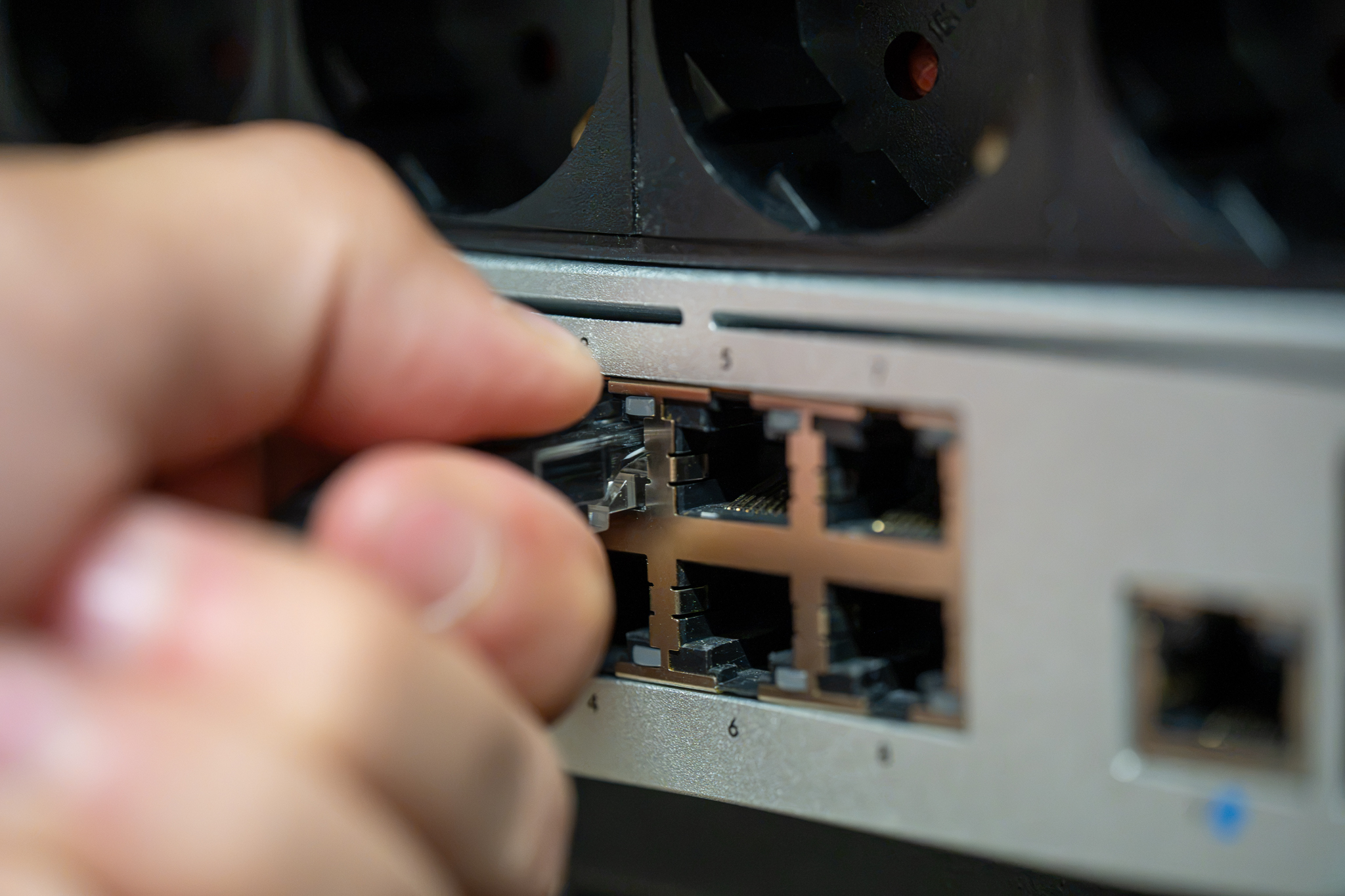 Network patch cable being clicked into a switch port