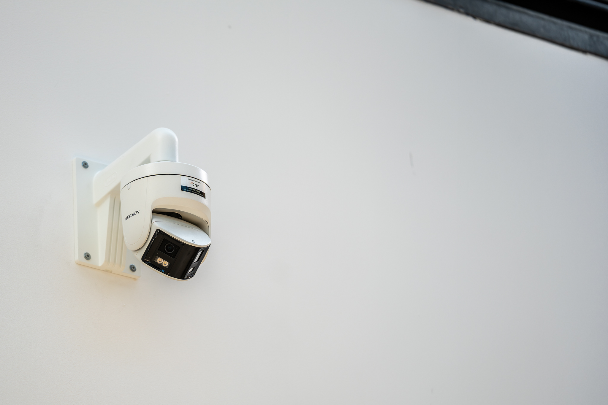 Wall-mounted outdoor security camera at a business entrance