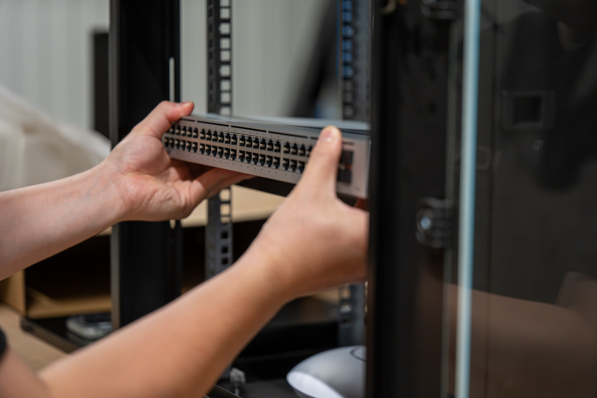 Technician mounting a network switch into a server rack